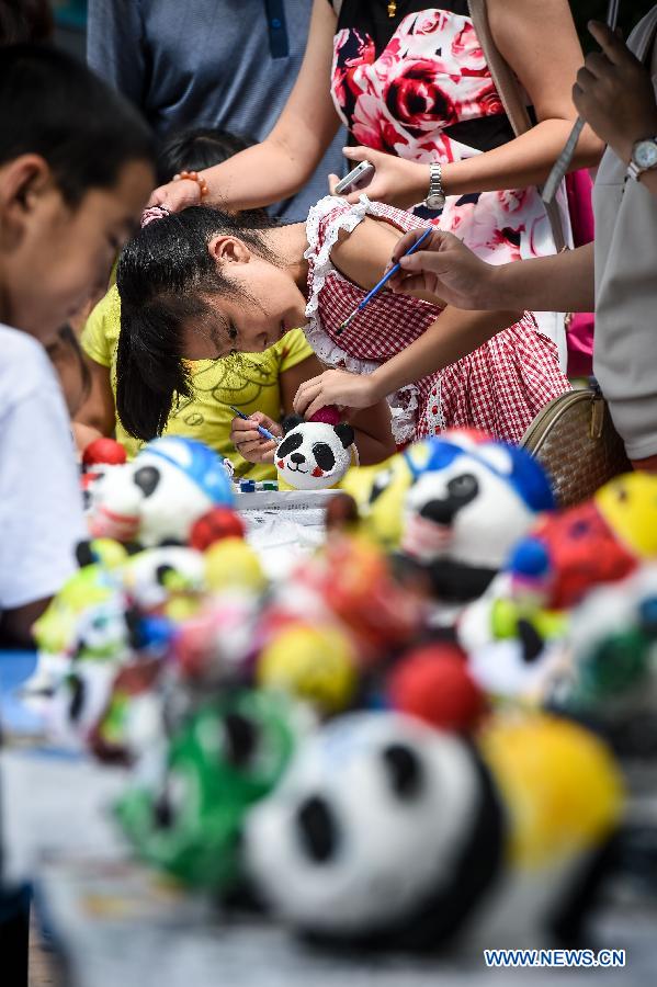 Children color plaster giant panda casts in the Taiyuan Zoo, Taiyuan city, capital of north China's Shanxi Province, Aug. 4, 2015.