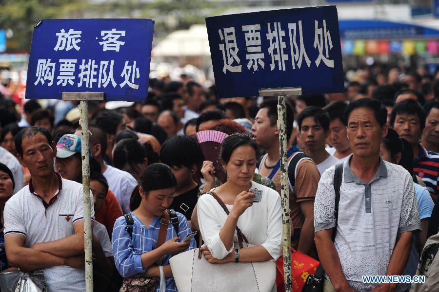 Passengers line up to reschedule or get a refund for tickets on the square of Lanzhou Railway Station in Lanzhou, capital city of northwest China's Gansu Province, Aug. 5, 2015. 