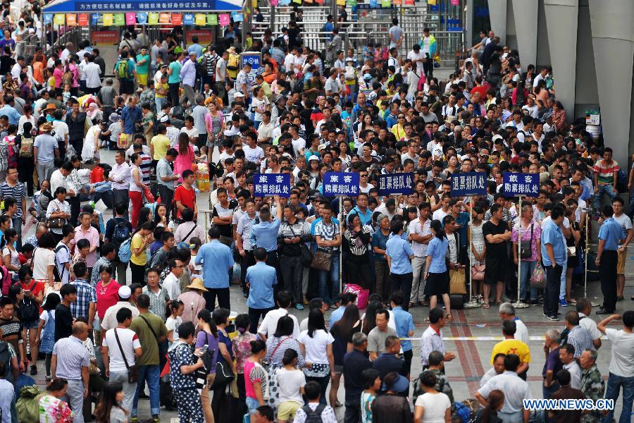 Passengers line up to reschedule or get a refund for tickets on the square of Lanzhou Railway Station in Lanzhou, capital city of northwest China's Gansu Province, Aug. 5, 2015.