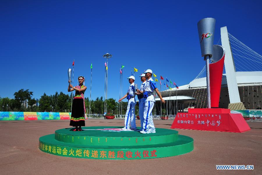 Torch bearer Yu Qunying of Lisu ethnic group attends the torch relay of the 10th Chinese Traditional Games of Ethnic Minorities in Erdos, Inner Mongolia Autonomous Region, China on Aug. 6, 2015.