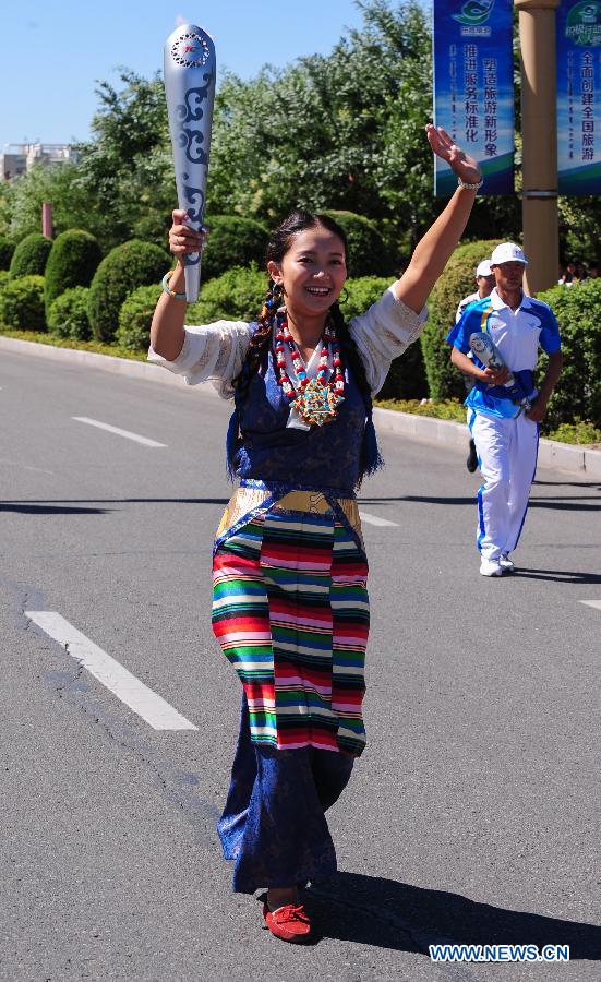 Torch bearer Deyang from Tibet runs in the torch relay of the 10th Chinese Traditional Games of Ethnic Minorities in Erdos, Inner Mongolia Autonomous Region, China on Aug. 6, 2015.