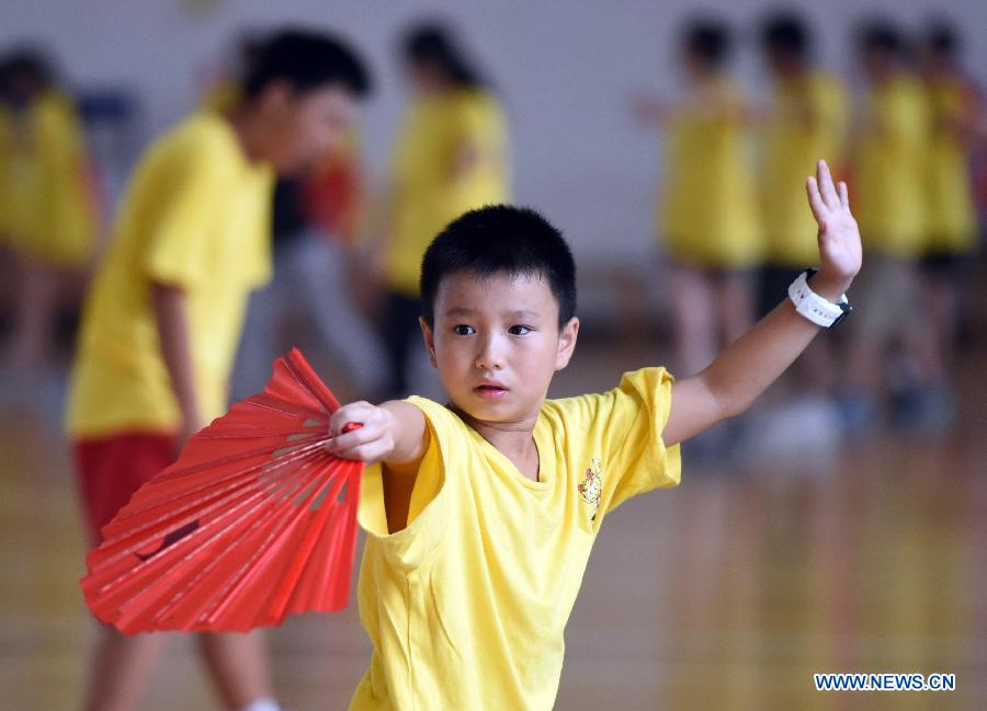 Overseas Chinese youth learn to perform Kung Fu Fan during the 'Chinese Root-Seeking Tour' Summer Camp in Beijing, capital of China, Aug. 7, 2015.