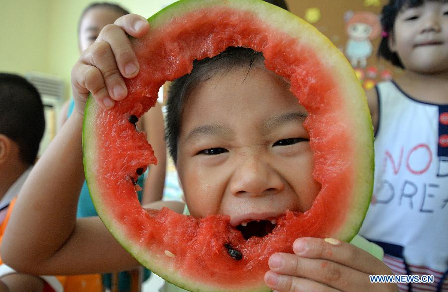 A child eats watermelon to meet the coming solar term 'beginning of autumn' at a kindergarten in Handan, north China's Hebei Province, Aug. 7, 2015. 