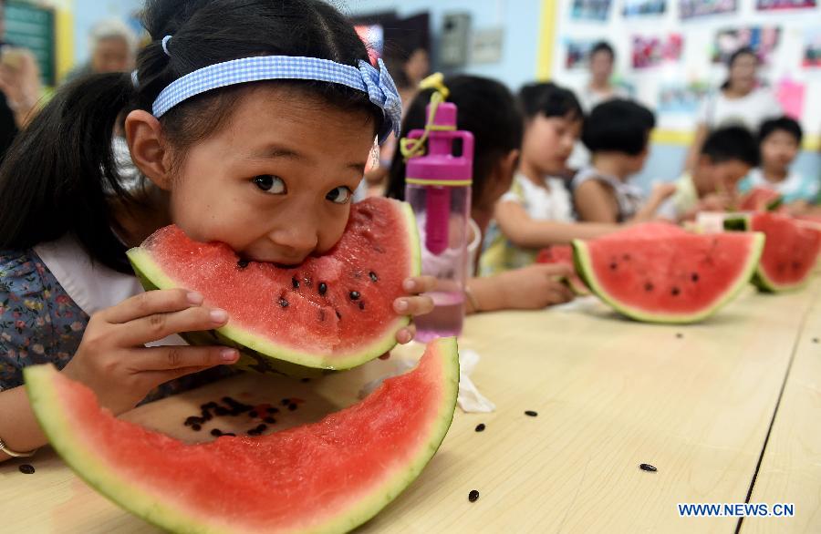 Children eat watermelons to meet the coming solar term 'beginning of autumn' in Hefei, capital of east China's Anhui Province, Aug. 7, 2015. 