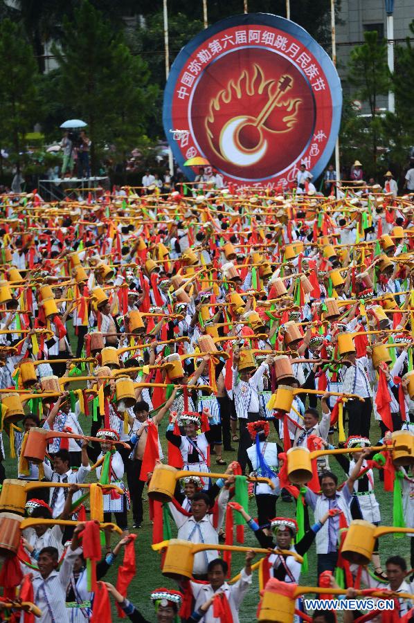 Axi people, a branch of the Yi ethnic group, celebrate their traditional festival named 'Axi Tiaoyue', or 'Axi Dance under Moonlight', in the stadium of Mile, southwest China's Yunnan Province, Aug. 7, 2015.