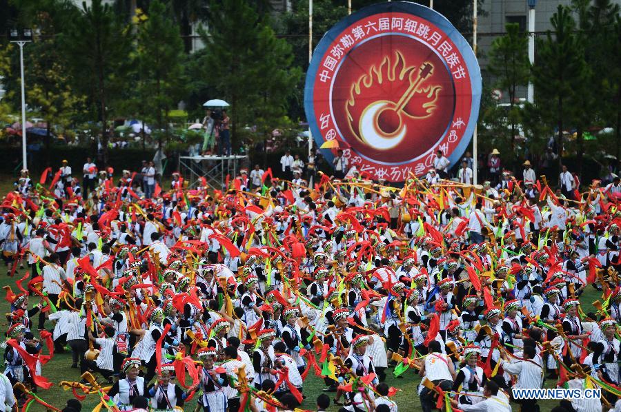 Axi people, a branch of the Yi ethnic group, celebrate their traditional festival named 'Axi Tiaoyue', or 'Axi Dance under Moonlight', in the stadium of Mile, southwest China's Yunnan Province, Aug. 7, 2015. 