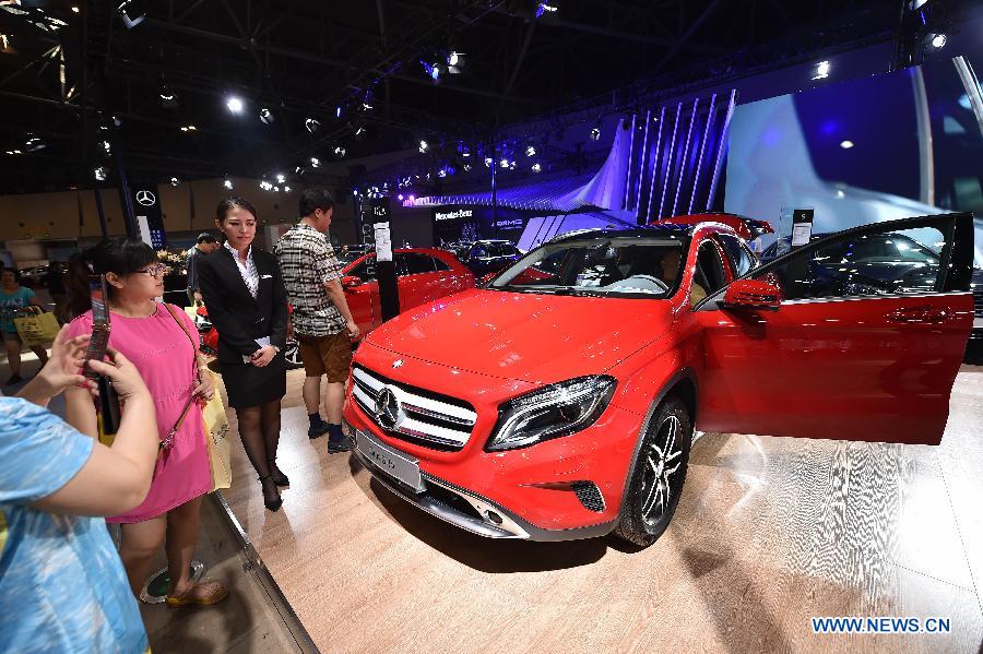 Visitors view a car on display during Taiyuan International Auto Show at Coal Transaction Center in Taiyuan, capital of China's north Shanxi province Aug. 6, 2015. 