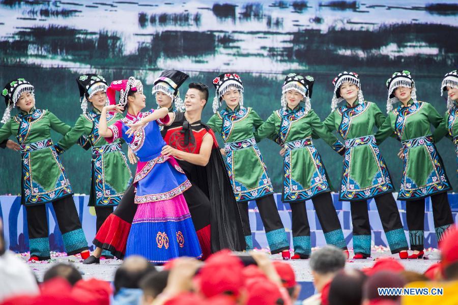 Performers dance on the opening ceremony of 'Cuotaiji' tourism and culture festival in Yi-Hui-Miao Autonomous County of Weining, southwest China's Guizhou Province, Aug. 8, 2015.