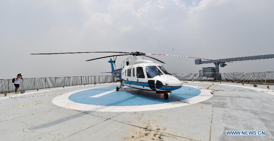 Photo taken on Aug. 7, 2015 shows a helicopter of Astro Air sitting parked on the top of an office building in downtown Shenzhen, south China's Guangdong Province. 
