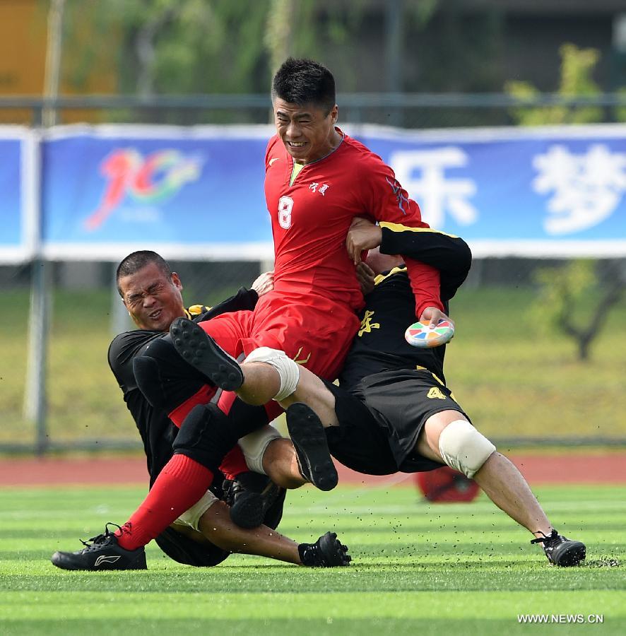 Athlete Ma Guolong (C) from northwest China's Ningxia Hui Autonomous Region is being besieged by rival athletes from south China's Guangdong Province in the first round of the fire-cracker catching games during the 10th National Traditional Games of Ethnic Minorities of China in Ordos, north China's Inner Mongolia Autonomous Region, Aug. 10, 2015.