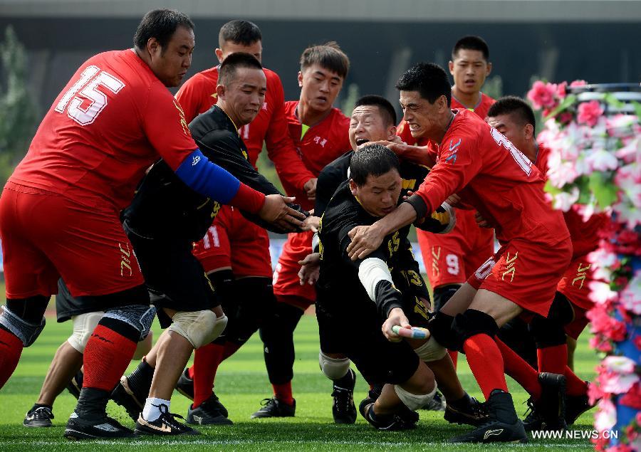 Athlete Huang Yayun (C) from south China's Guangdong Province breaks through the defense in the first round of the fire-cracker catching games during the 10th National Traditional Games of Ethnic Minorities of China in Ordos, north China's Inner Mongolia Autonomous Region, Aug. 10, 2015.