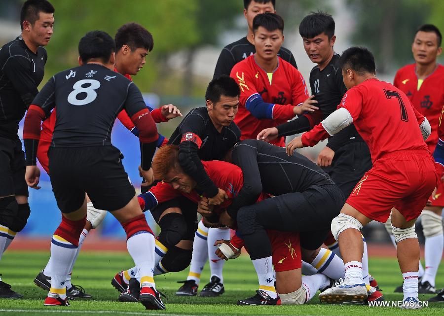 Athlete Liu Cheng (bottom) from south China's Guangxi Zhuang Autonomous Region is being besieged by rival athletes from north China's Inner Mongolia Autonomous Region in the first round of the fire-cracker catching games during the 10th National Traditional Games of Ethnic Minorities of China in Ordos, north China's Inner Mongolia Autonomous Region, Aug. 10, 2015.