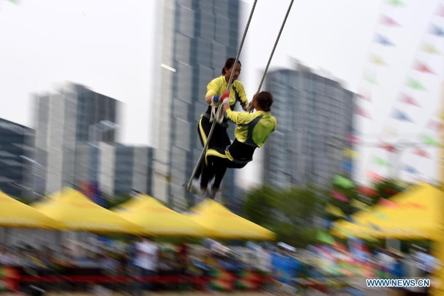 Athletes Wu Anzhen (R) and Fei Qianhong from central China's Hunan Province compete in a doule game of swing during the 10th National Traditional Games of Ethnic Minorities of China in Ordos, north China's Inner Mongolia Autonomous Region, Aug. 10, 2015.