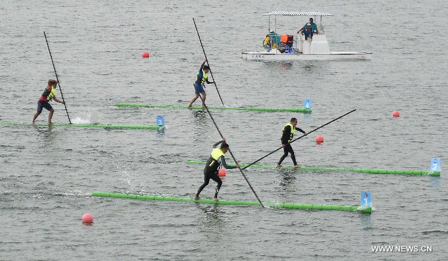 Athletes compete in a men's preliminary match of single bamboo drifting, a specialty originated from southwest China's Guizhou Province, during the 10th National Traditional Games of Ethnic Minorities of China in Ordos, north China's Inner Mongolia Autonomous Region, Aug. 10, 2015. 