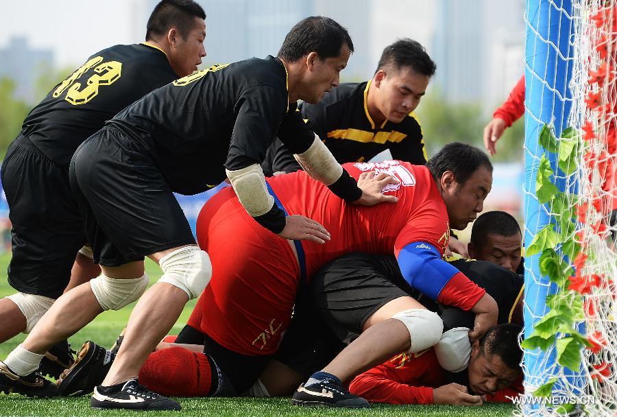 Athlete Yang Shaohu (bottom) from northwest China's Ningxia Hui Autonomous Region is being besieged by rival athletes from south China's Guangdong Province in the first round of the fire-cracker catching games during the 10th National Traditional Games of Ethnic Minorities of China in Ordos, north China's Inner Mongolia Autonomous Region, Aug. 10, 2015