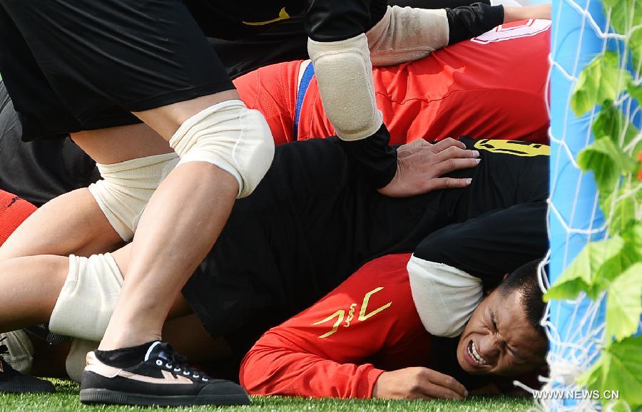 Athlete Yang Shaohu (bottom) from northwest China's Ningxia Hui Autonomous Region is being besieged by rival athletes from south China's Guangdong Province in the first round of the fire-cracker catching games during the 10th National Traditional Games of Ethnic Minorities of China in Ordos, north China's Inner Mongolia Autonomous Region, Aug. 10, 2015.