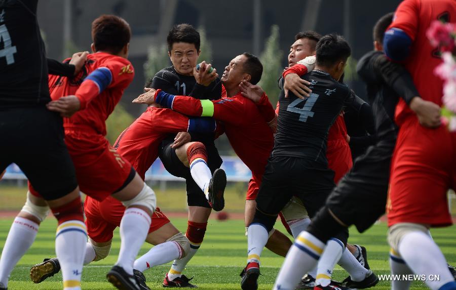 Athlete Zhang Jianlei (C) from north China's Inner Mongolia Autonomous Region is being besieged by rival athletes from south China's Guangxi Zhuang Autonomous Region in the first round of the fire-cracker catching games during the 10th National Traditional Games of Ethnic Minorities of China in Ordos, north China's Inner Mongolia Autonomous Region, Aug. 10, 2015.