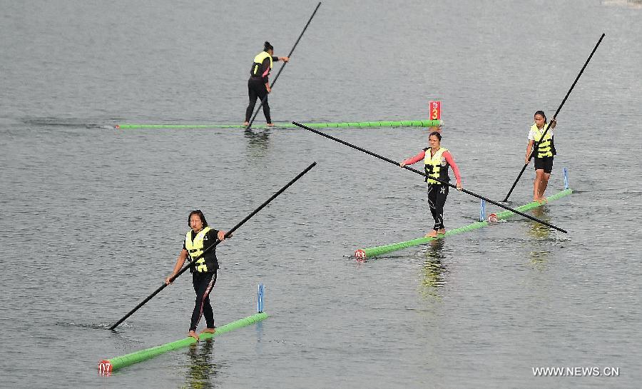 Athletes prepare to compete in a women's preliminary match of single bamboo drifting, a specialty in southwest China's Guizhou Province, during the 10th National Traditional Games of Ethnic Minorities of China in Ordos, north China's Inner Mongolia Autonomous Region, Aug. 10, 2015.