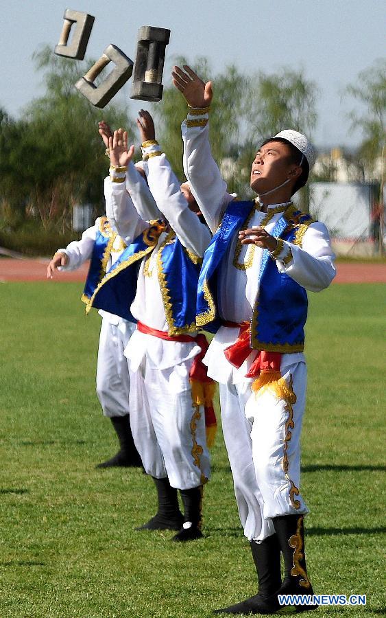 Athletes from central China's Henan Province perform a kind of traditional sport event during the 10th National Traditional Games of Ethnic Minorities of China in Ordos, north China's Inner Mongolia Autonomous Region, Aug. 15, 2015.