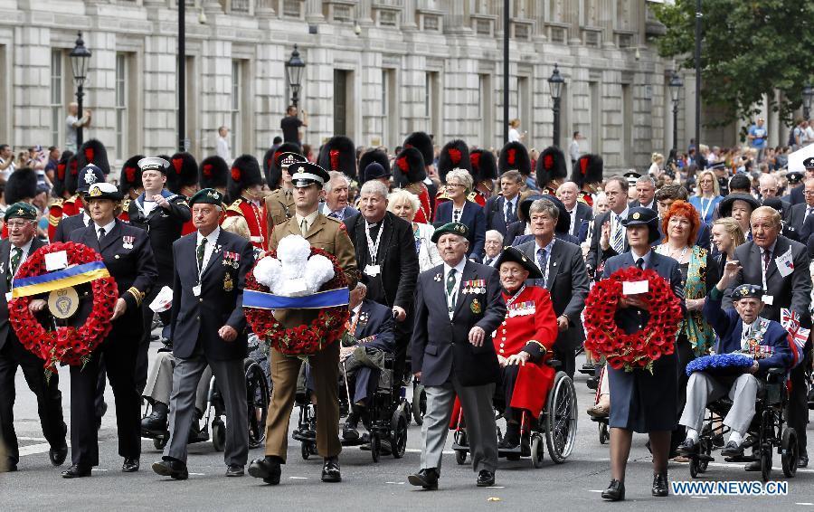 Veterans and their families pass by the Whitehall in central London as they take part in a parade from Horse Guards Parade to Westminster Abbey after a service of commemoration during the 70th Anniversary commemorations of VJ Day (Victory over Japan) in London, Britain, on Aug. 15, 2015. (Xinhua/Han Yan) 