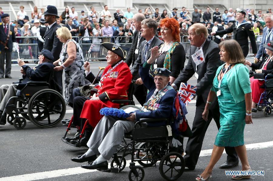 Veterans and their families pass by the Whitehall in central London as they take part in a parade from Horse Guards Parade to Westminster Abbey after a service of commemoration during the 70th Anniversary commemorations of VJ Day (Victory over Japan) in London, Britain, on Aug. 15, 2015. (Xinhua/Han Yan) 