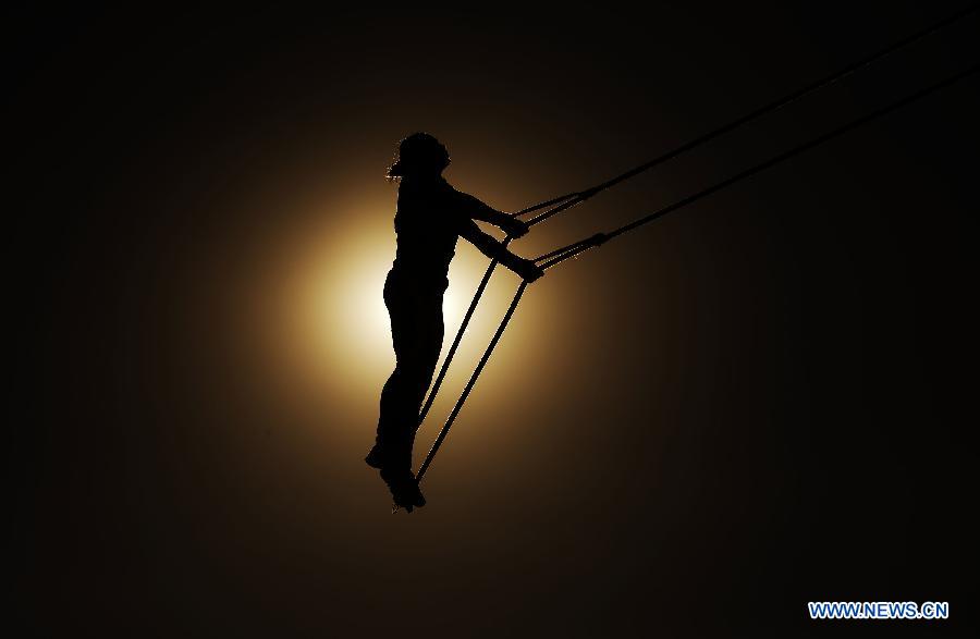 An athlete from central China's Hunan Province competes in a +55kg match of the Swing event during the 10th National Traditional Games of Ethnic Minorities of China in Ordos, north China's Inner Mongolia Autonomous Region, Aug. 14, 2015. 