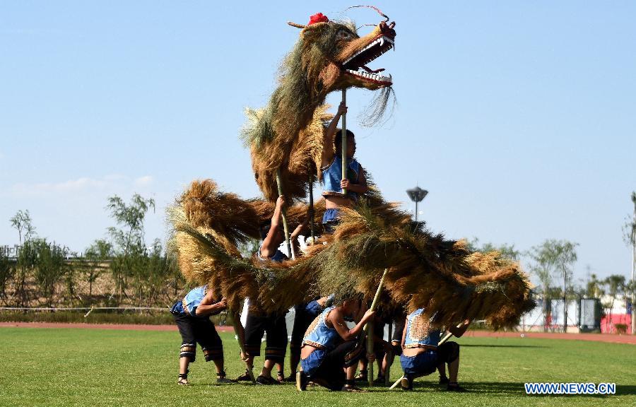 Athletes from southwest China's Guizhou Province perform a kind of original dragon dance during the 10th National Traditional Games of Ethnic Minorities of China in Ordos, north China's Inner Mongolia Autonomous Region, Aug. 15, 2015.