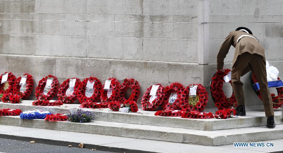 A soldier adjusts a wreath after a service of commemoration during the 70th Anniversary commemorations of VJ Day (Victory over Japan) in London, Britain, on Aug. 15, 2015. (Xinhua/Han Yan) 