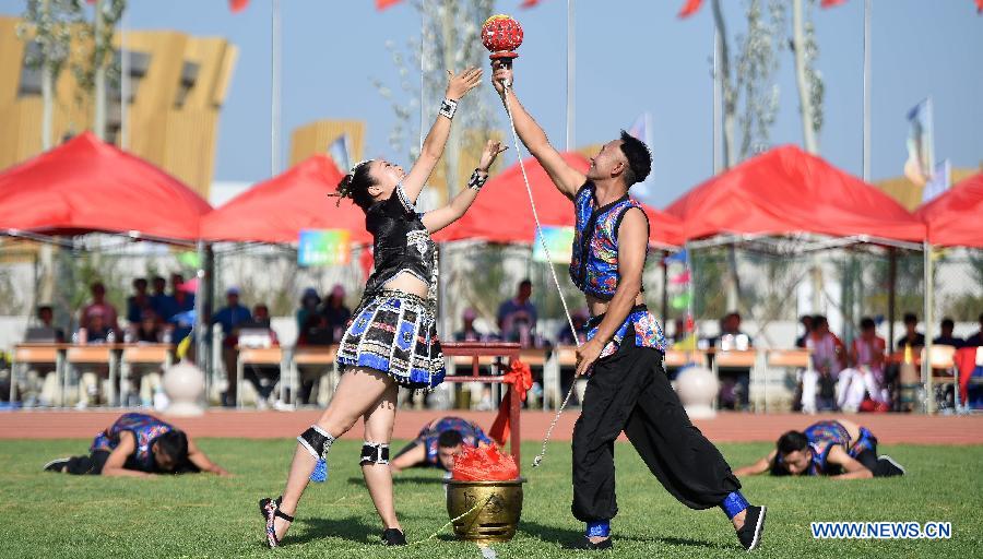 Athletes from central China's Hunan Province perform a kind of traditional sport event during the 10th National Traditional Games of Ethnic Minorities of China in Ordos, north China's Inner Mongolia Autonomous Region, Aug. 15, 2015. 