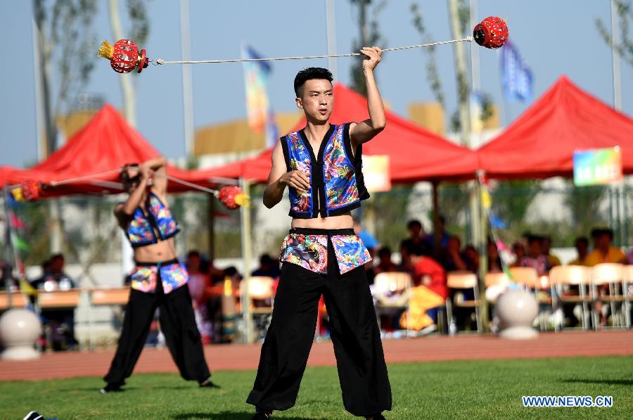 Athletes from central China's Hunan Province perform a kind of traditional sport event during the 10th National Traditional Games of Ethnic Minorities of China in Ordos, north China's Inner Mongolia Autonomous Region, Aug. 15, 2015. 