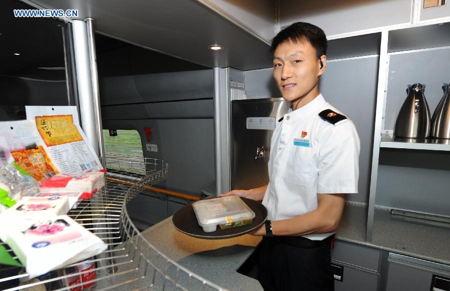 A steward prepares lunch for passengers on the high-speed train D7989, northeast China's Heilongjiang Province, Aug. 17, 2015. 