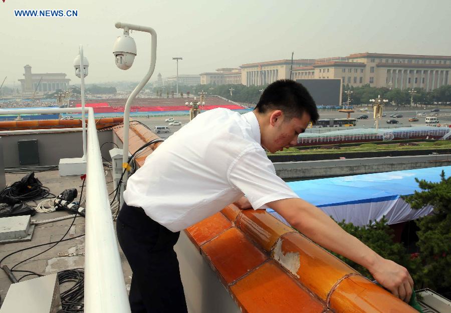 A staff worker cleans glazed tiles at the Tian'anmen Rostrum in Beijing, capital of China, Aug. 17, 2015. 