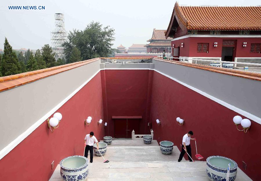 Staff workers sweep the step at the Tian'anmen Rostrum in Beijing, capital of China, Aug. 17, 2015.