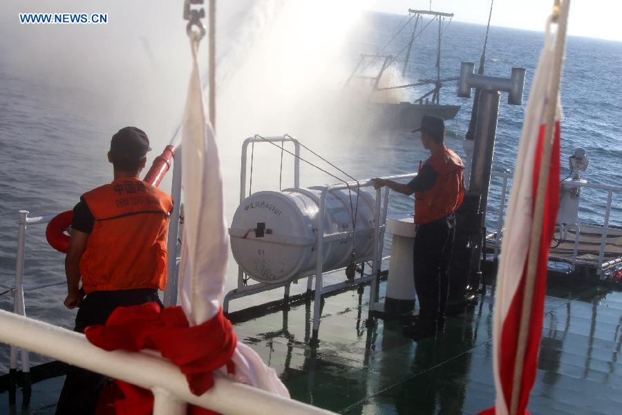 Rescuers try to put out fire of a fishing vessel sailing six nautical miles off the coast of Wenchang, south China's Hainan Province, Aug. 17, 2015.