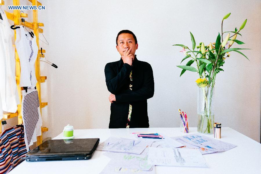 Fashion designer Genqoi Tashi reacts in his workshop in Lhasa, capital of southwest China's Tibet Autonomous Region, Aug. 12, 2015.