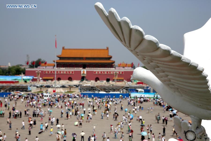 Photo taken on Aug. 20, 2015 shows a dove model flying above a parterre with the Great Wall pattern at the Tian'anmen Square in Beijing, capital of China. 