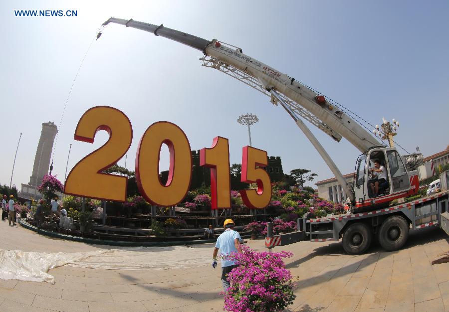 Workers build a parterre with the Great Wall pattern at the Tian'anmen Square in Beijing, capital of China, Aug. 20, 2015.