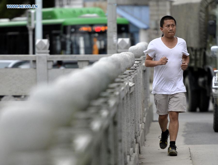 Genqoi Tashi jogs at the bank of the Lhasa River in Lhasa, capital of southwest China's Tibet Autonomous Region, Aug. 16, 2015. 