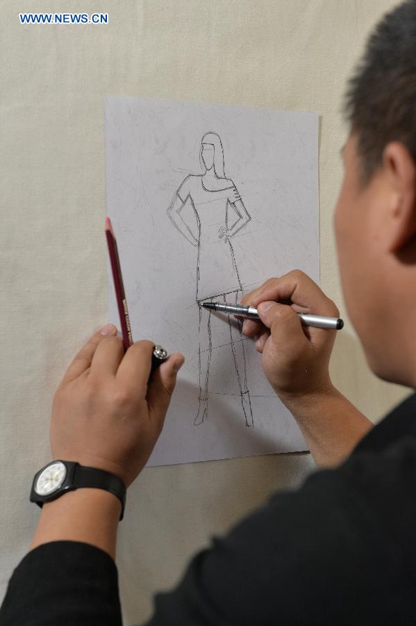 Genqoi Tashi draws design sketches in Lhasa, capital of southwest China's Tibet Autonomous Region, Aug. 12, 2015. 