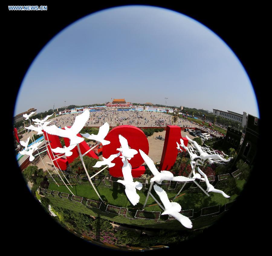 Photo taken on Aug. 20, 2015 shows dove models flying above a parterre with the Great Wall pattern at the Tian'anmen Square in Beijing, capital of China.