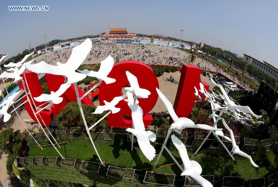 Photo taken on Aug. 20, 2015 shows dove models flying above a parterre with the Great Wall pattern at the Tian'anmen Square in Beijing, capital of China. 