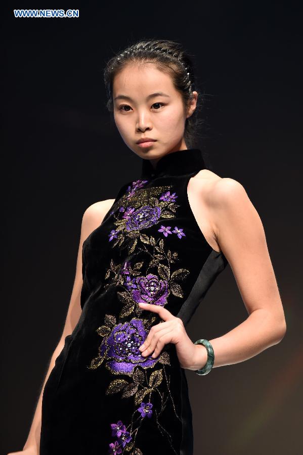 A model presents cheongsam, a traditional Chinese women's dress also known as Qipao, during a show in Kunming, southwest China's Yunnan Province, Aug. 21, 2015. 