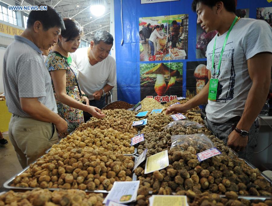 People select products at an agricultural products trade fair in Guiyang, capital of southwest China's Guizhou Province, Aug. 21, 2015. 