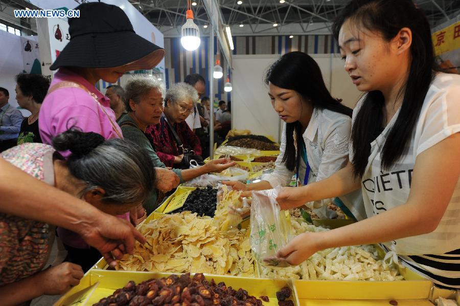 People select products at an agricultural products trade fair in Guiyang, capital of southwest China's Guizhou Province, Aug. 21, 2015. The three-day trade fair kicked off here Friday. 