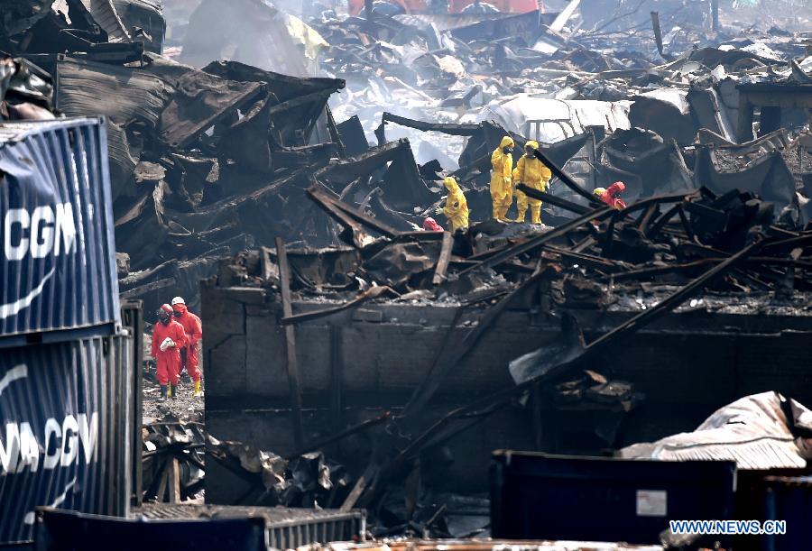 Rescuers clean up the debris at the core blast site in Tianjin, north China, Aug. 22, 2015. 