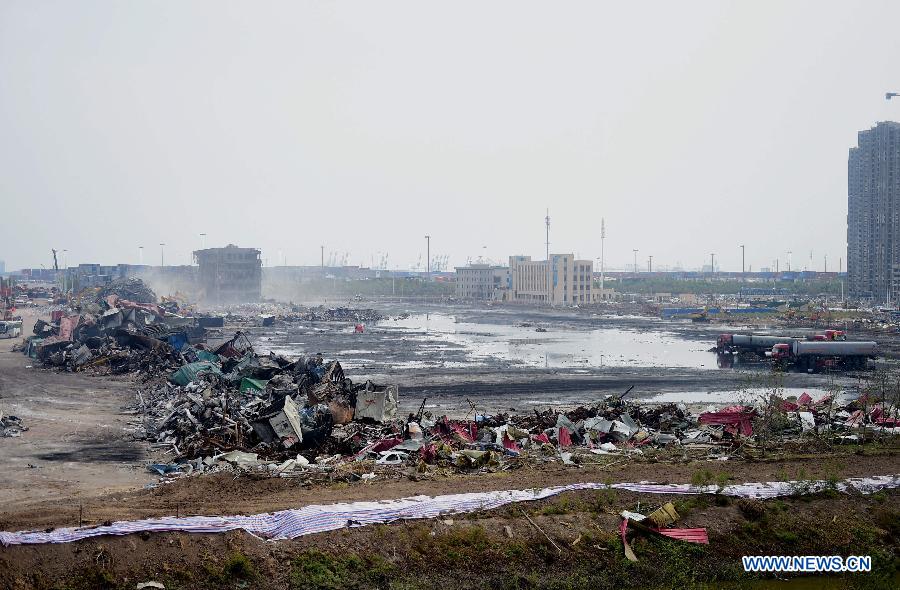 Debris near the core area of explosion site is cleared up in Tianjin, north China, Aug. 25, 2015.