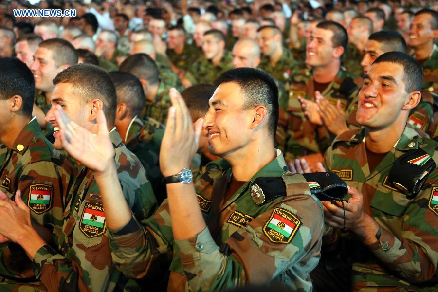 Foreign officers and soldiers, who will participate in China's military parade on Sept. 3, applaud as they watch a performance in a party at military parade training base in Beijing, capital of China, Aug. 25, 2015.
