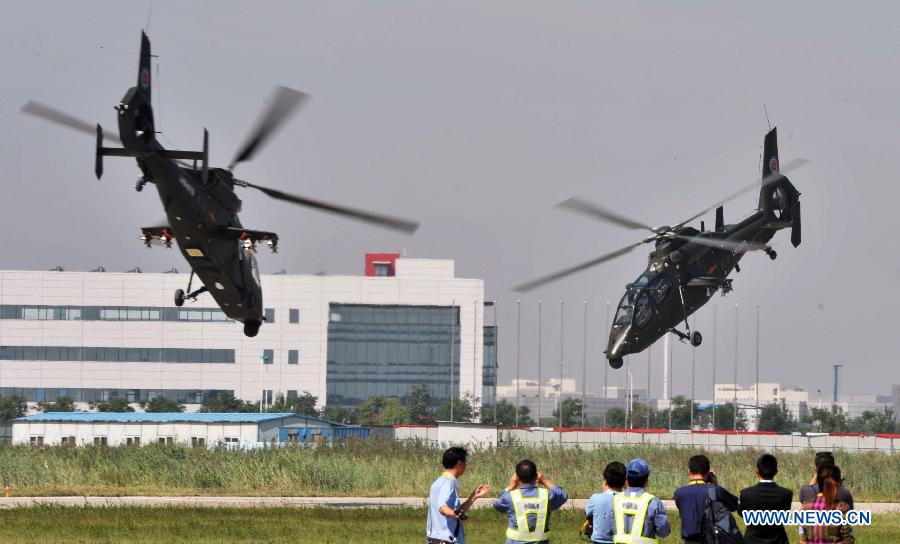 Gunships practise low-altitude flight for the coming China Helicopter Exposition in a helicopter base of Aviation Industry Corporation of China in the Airport Area of China Pilot Free Trade Zone of Tianjin, north China, Sept. 7, 2015. 