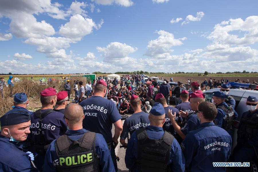 Illegal migrants walk on railway tracks after crossing the border between Hungary and Serbia near Roszke, a village on the Serbian-Hungarian border, Hungary, on Sept. 7, 2015. 