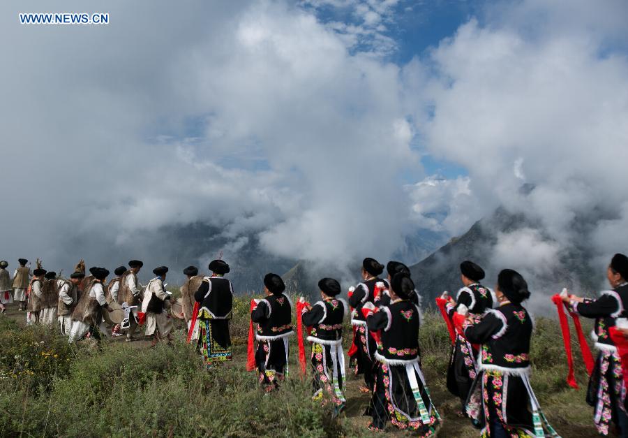 People of Qiang ethnic group dance in an event to worship the god 'Baihaha' in Xishan Village of Lixian County, southwest China's Sichuan Province, Sept. 20, 2015.